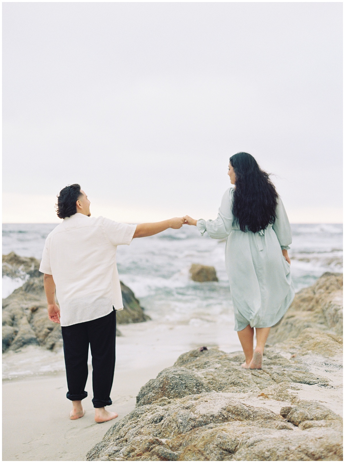 Film Portra 800 of couple at the beach holding hands and playing