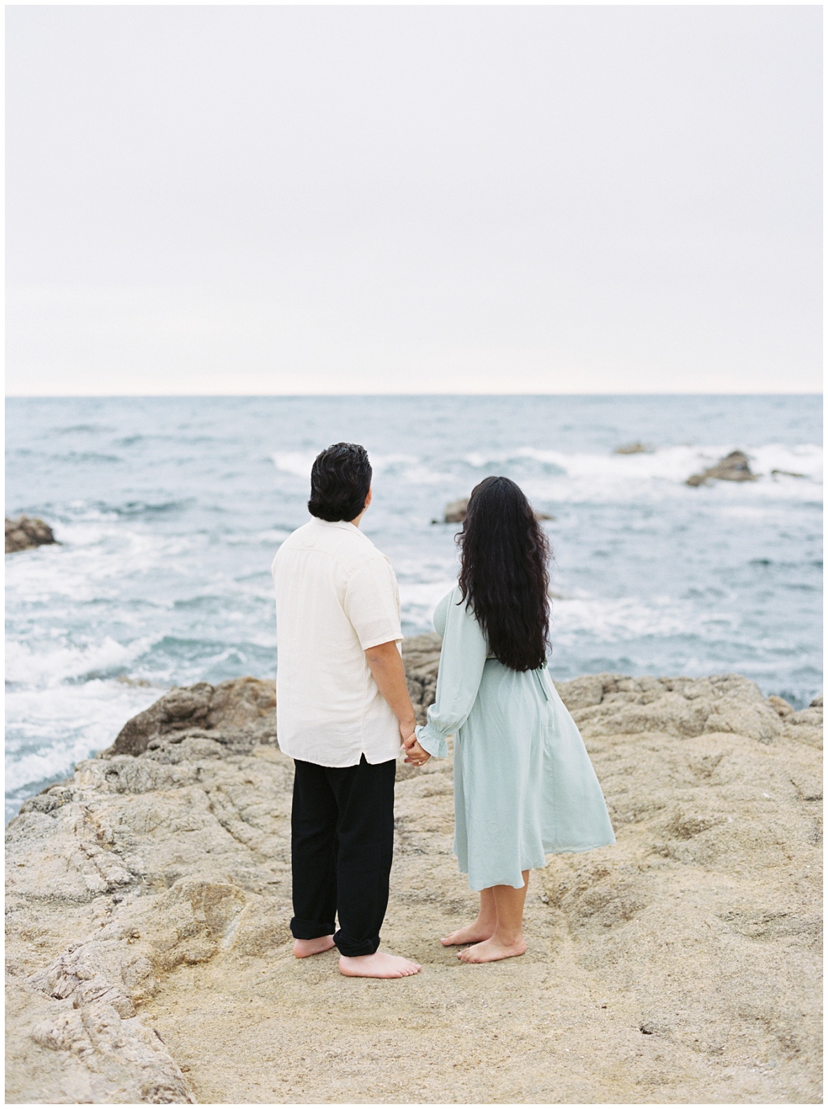 Couple looking out into the ocean at Monterey coast.