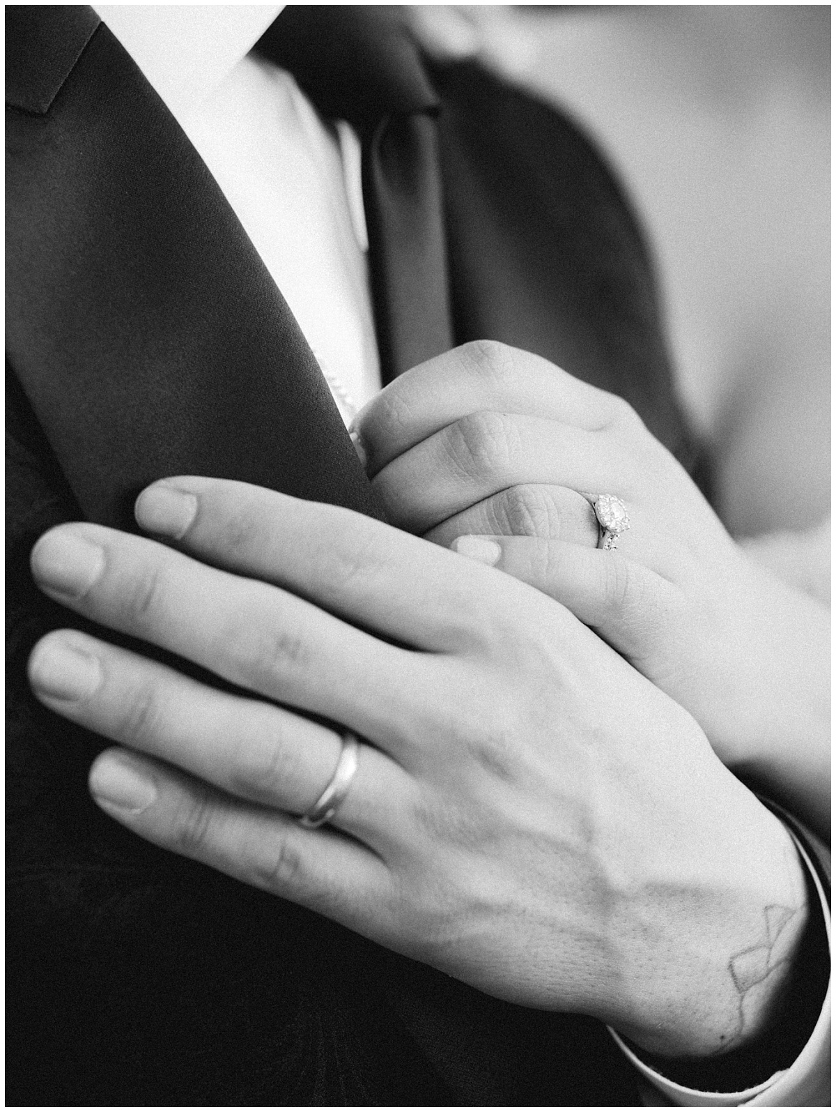 A classic black and white detail shot of the couple hands with their rings